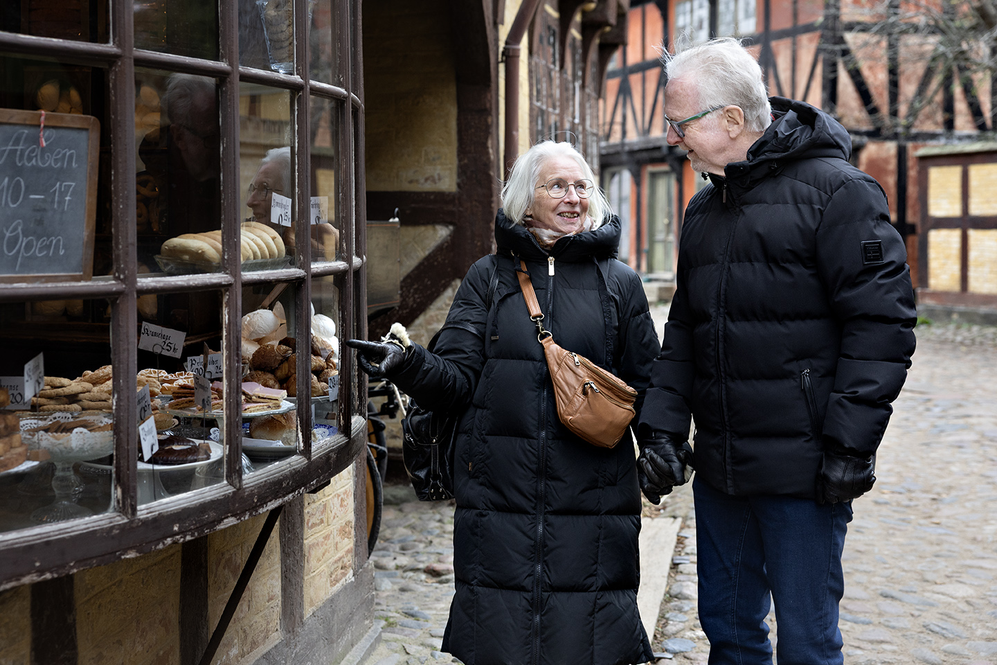 Ægtepar står foran en bagerforretning i Den Gamle By