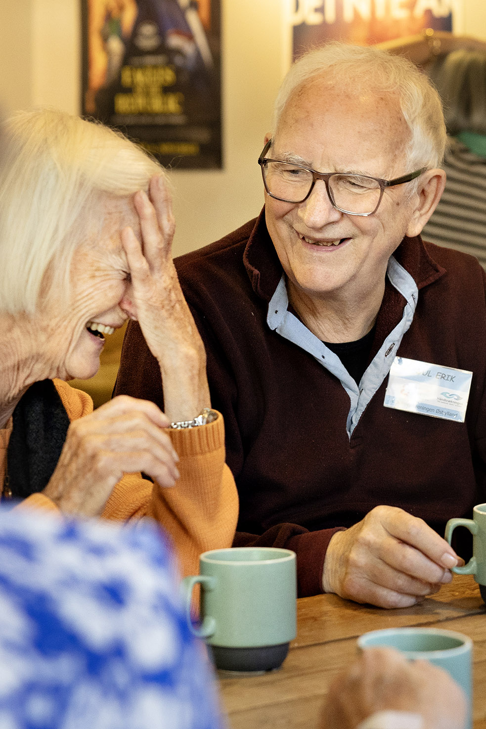 To deltagere i filmfremvisningen sidder i foyeren og griner