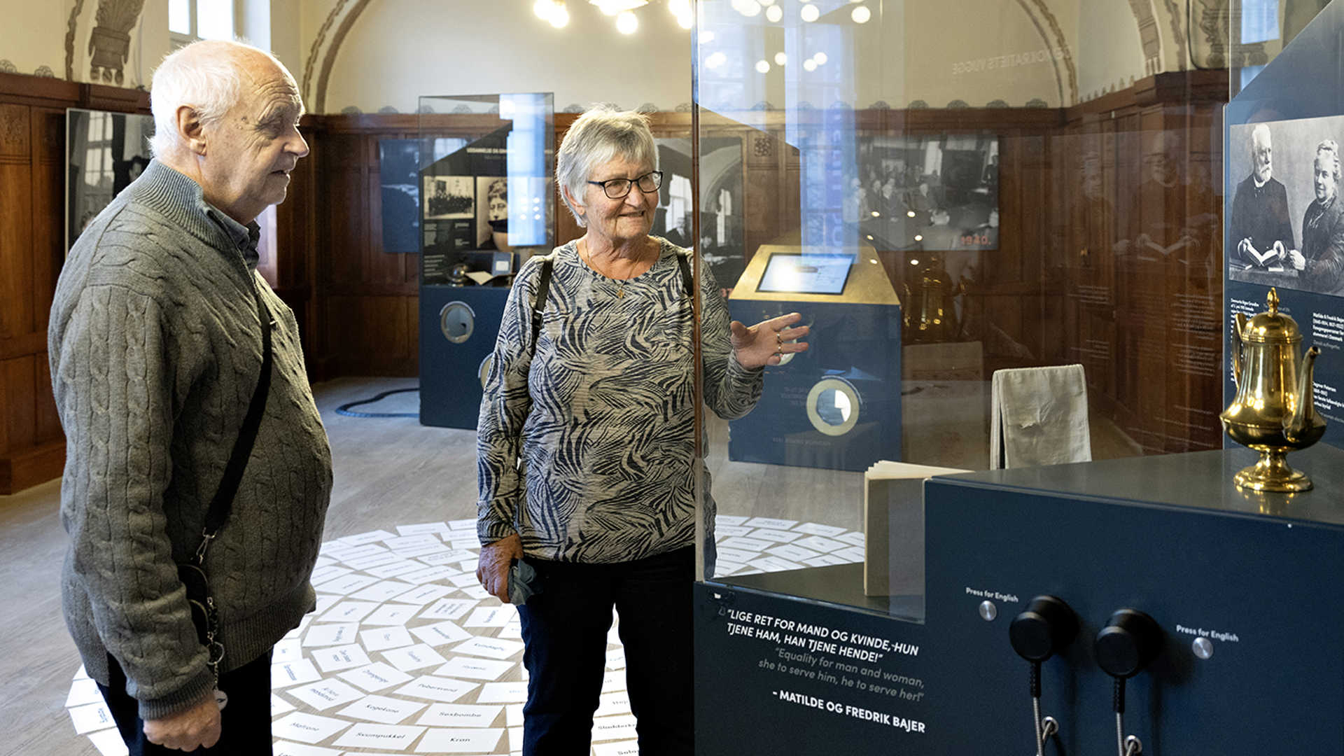 En kvinde og en mand kigger på museumsgenstande på KØN