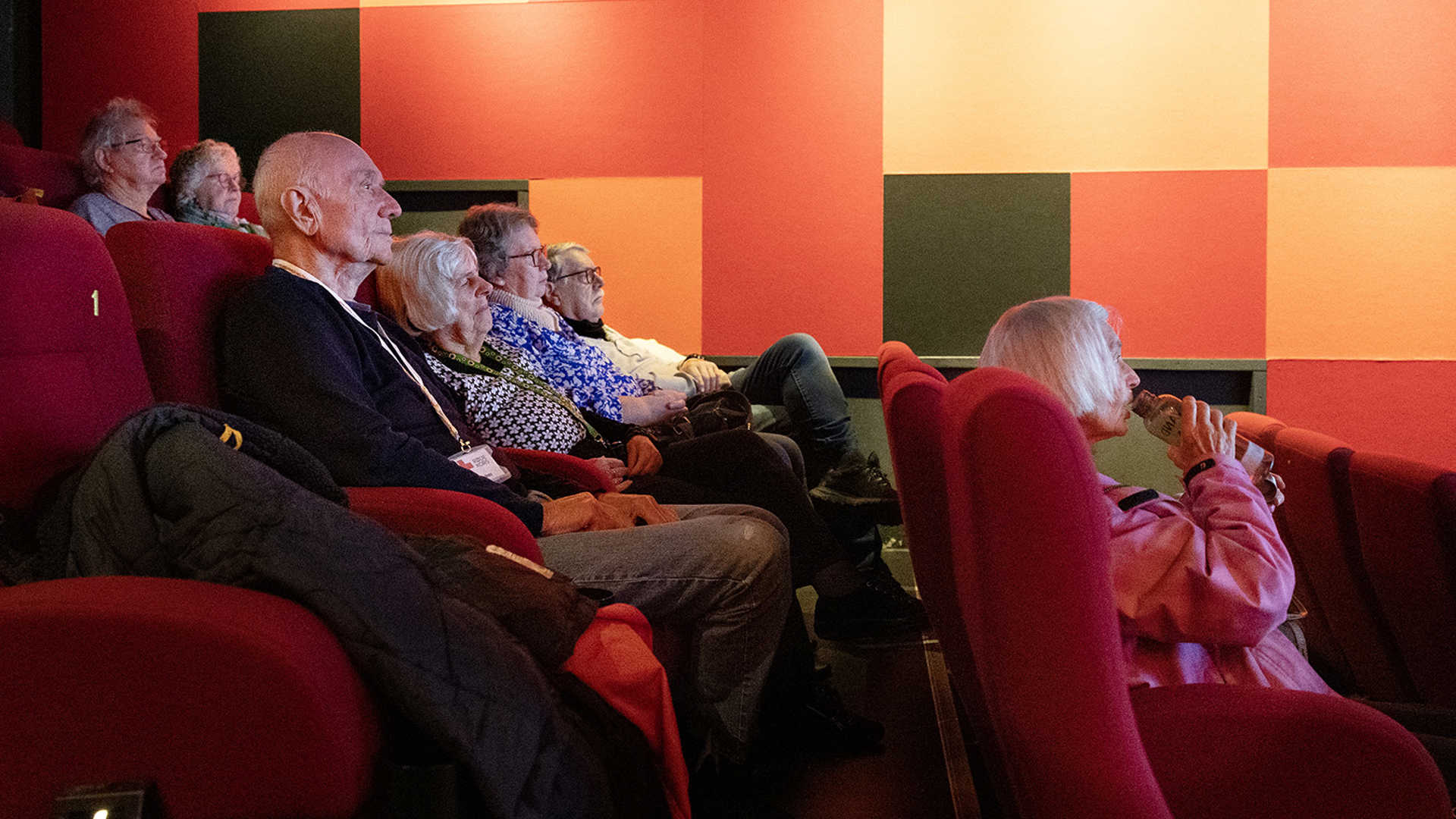 Den demensvenlig filmforevisning begynder og deltagerne er på plads i biografen