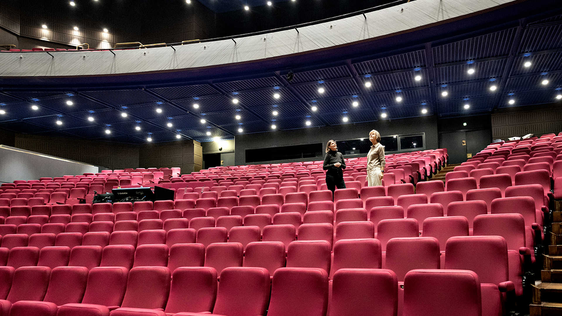 To kvinder står blandt stolerækkerne i Musikhuset